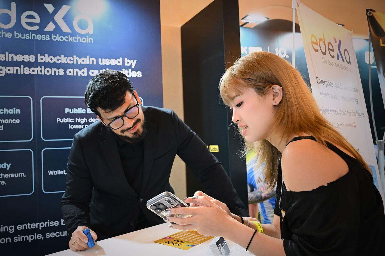 edeXa booth visitor scanning on-chain QR with team member